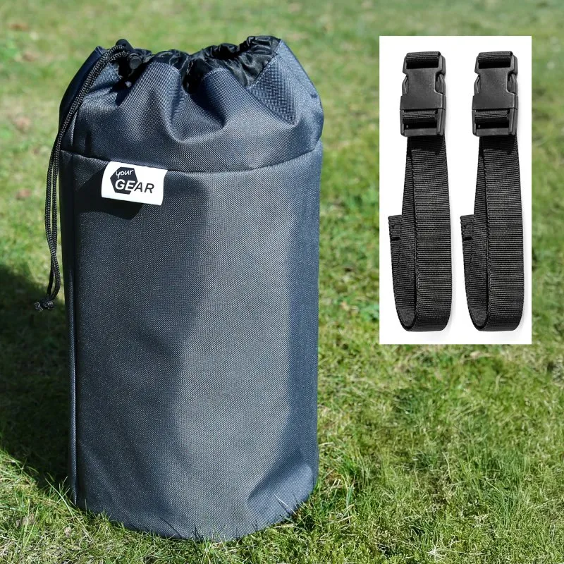 Housse cylindrique noire avec cordon de serrage étiquetée "your GEAR" posée sur l'herbe, accompagnée de deux sangles noires à boucles plastique sur fond blanc.