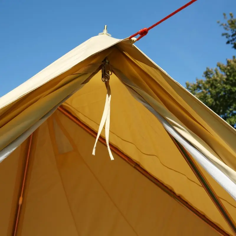 Zeltspitze des your GEAR Gobi 3 Tipi-Zelts aus Baumwoll-Mischgewebe mit UV50+ Schutz, innovativem Gestänge ohne Mittelstange, sichtbarem A-Rahmen-Eingang und Abspannseil vor blauem Himmel.