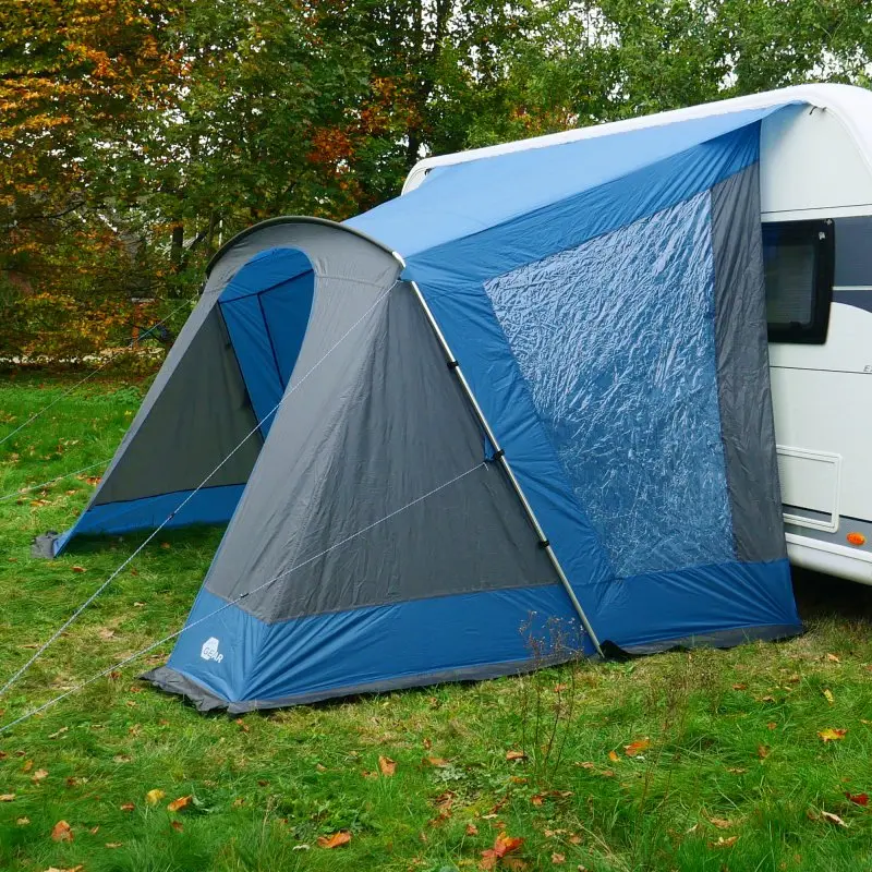 your GEAR Sharki 330 Wohnwagen Sonnendach mit Alugestänge, zwei großen Seitenfenstern, blau-grauem Stoff, am Caravan befestigt, auf einer Wiese stehend, ideal als Vorzelt für Camping und Kurzurlaube.