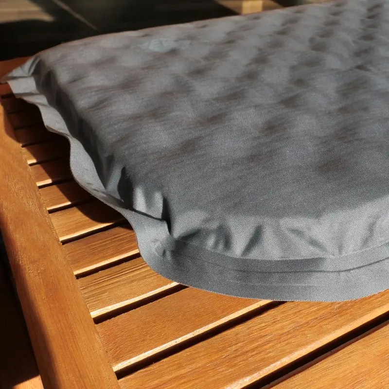 Cojín térmico yourGEAR autoinflable de 40x30x3,5 cm en color gris, con superficie acolchada y esquinas redondeadas, colocado sobre una superficie de madera, ideal para camping y exteriores.