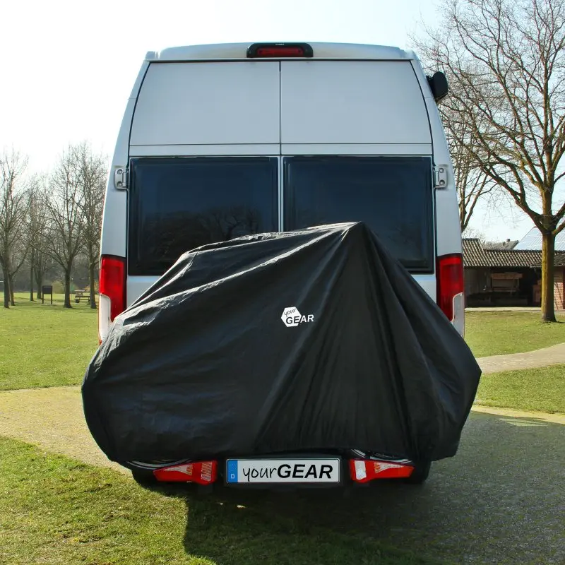 Waterproof yourGEAR Malaga bike cover for 2 bikes on a rear bike rack, mounted on a white van. The black protective cover fits over the top, sides, and front, featuring the yourGEAR logo.