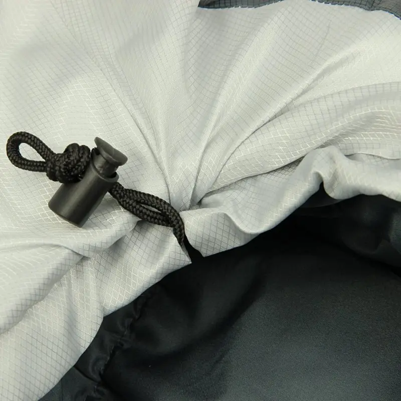 Chiusura a coulisse nera con fermaglio di plastica su tessuto grigio con motivo a quadretti.