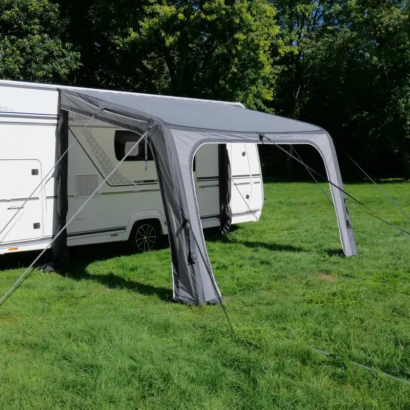 Auvent gonflable your GEAR Porto 340 Air gris, fixé à un camping-car, offrant une protection solaire et contre la pluie, avec structure à air et triple jonc, installé sur une pelouse verte.