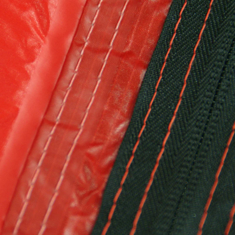 Gros plan sur la couture étanche d’un tissu rouge et noir du 10T Zelt Silicone Valley, montrant la qualité imperméable 5000mm et les coutures renforcées du campingzelt trekking 3 personnes.