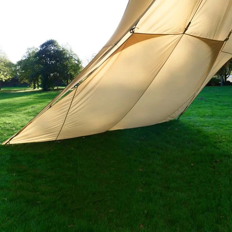 Paroi latérale beige your GEAR Sonora 10 fixée à un pavillon, tissu résistant et clips visibles, offre une grande zone d’ombre sur une pelouse verte pour protection solaire et intimité extérieure.