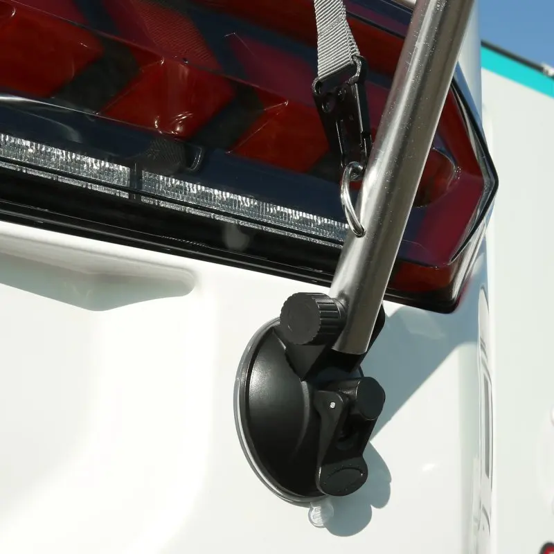 Soporte de ventosa de la Markise your GEAR Padua fijado en la carrocería de una caravana, con varilla telescópica de aluminio y correa de sujeción, ideal para protección solar y fácil instalación.