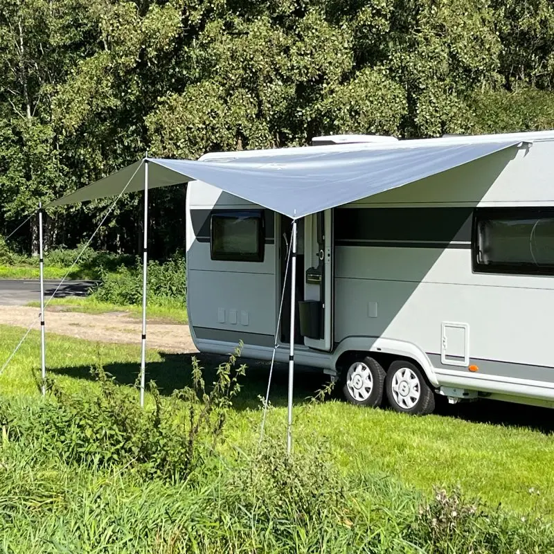 your GEAR Caravan Thermo Tarp 435 x 250 cm, UV80, opaque, waterproof awning with reflective aluminum coating, mounted on a caravan for sun and weather protection, shown outdoors on grass.