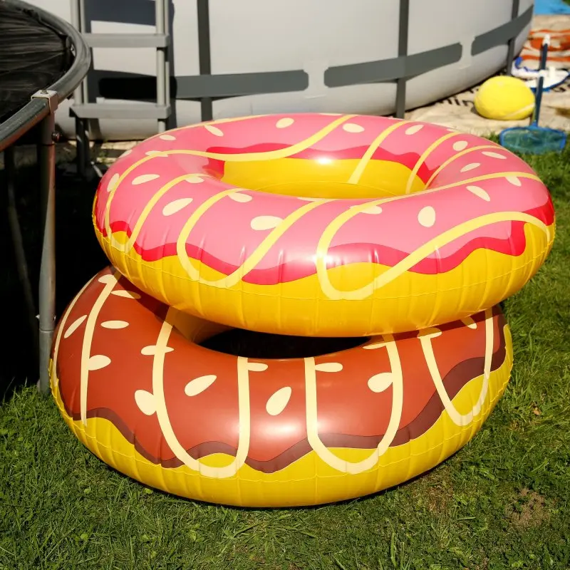 XL inflatable swim ring by Jilong in brown donut design, made of durable vinyl, diameter 110 cm, with a comfortable seating area, ideal as pool float or seat for adults and kids, shown outdoors near a pool.