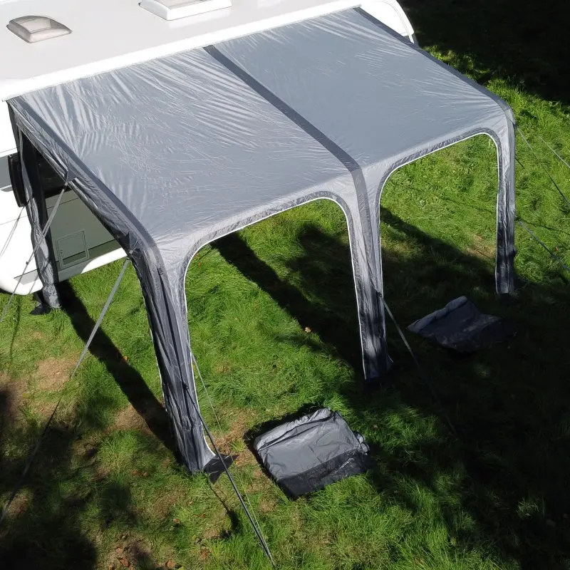Auvent gonflable your GEAR Porto 420 Air gris monté sur un camping-car, avec structure à air et triple jonc, offrant protection solaire et contre la pluie, installé sur herbe verte.