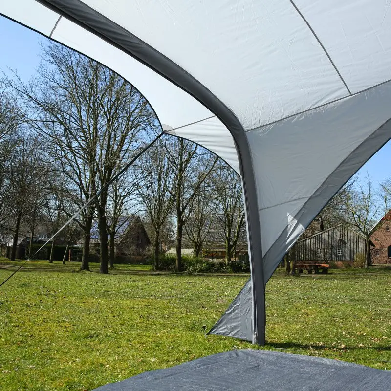 Tenda da sole your GEAR Amalfi Air 360 per caravan, struttura ad arco gonfiabile, tessuto grigio chiaro, montata su prato, ideale come veranda per Hobby Beachy 360/420/450, offre ombra e protezione.