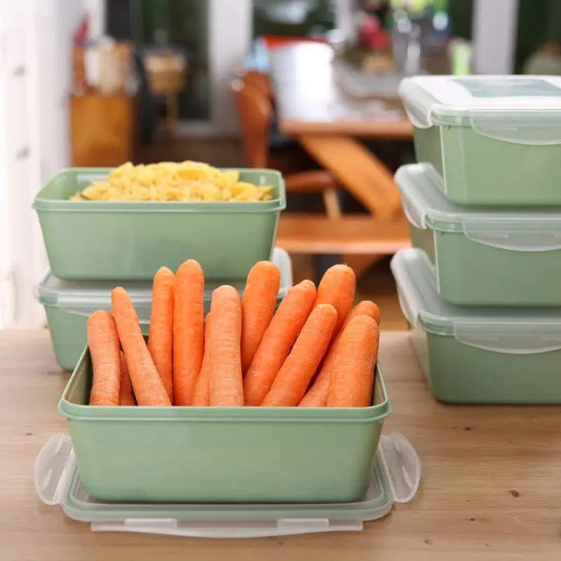 Set di 6 contenitori your GEAR Pila da 1350 ml con coperchio, impilabili e verdi, ideali per alimenti. Mostrati con carote e pasta, perfetti per conservare cibo in cucina, freezer e microonde.