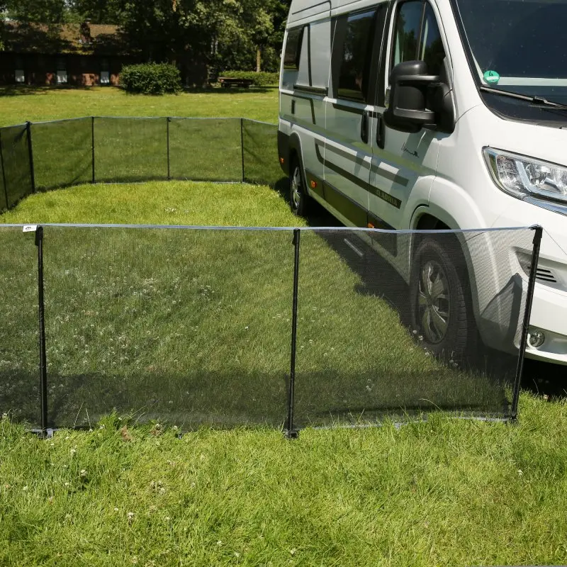 Mobile your GEAR Larino 400 dog fence, 90 cm high, black mesh panels connected by zippers, set up on grass next to a camper van; ideal as a portable, expandable enclosure for camping or garden use.