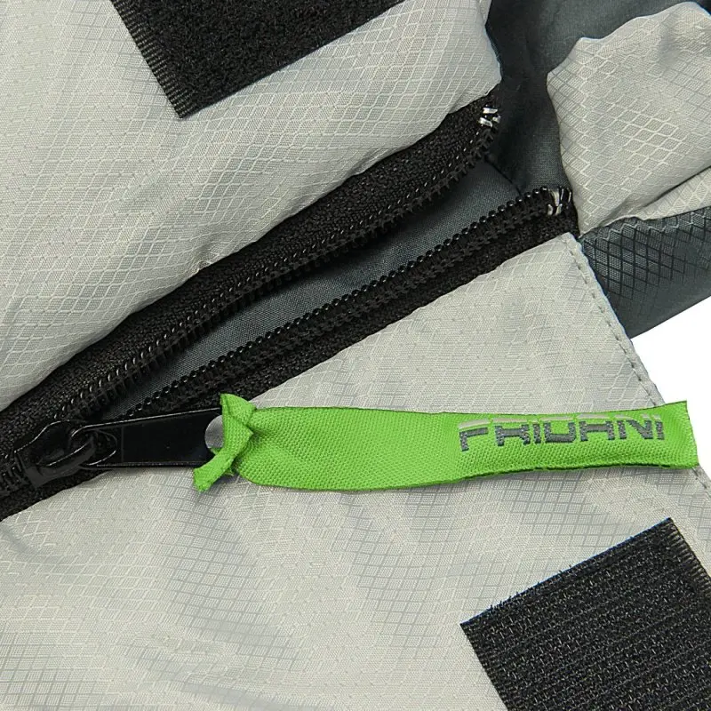 Primo piano di una cerniera nera su tessuto grigio con una linguetta verde con la scritta "FRIOLANI".