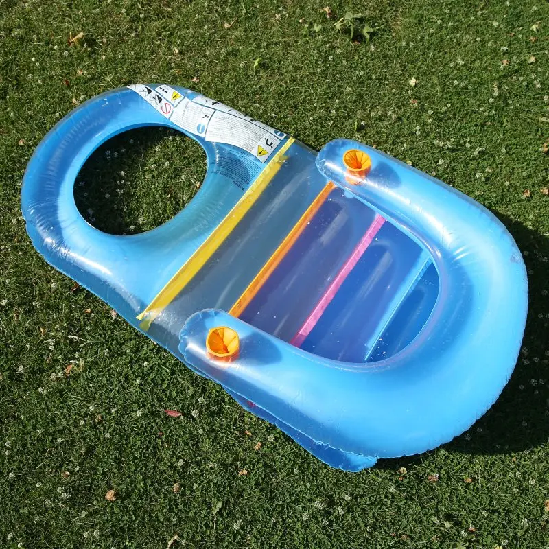 Sillón flotante inflable Jilong Fashion Lounge azul de 150x86 cm, con respaldo, portavasos y diseño colorido, ideal para piscina o playa. Producto sobre césped, apto para adultos y adolescentes.
