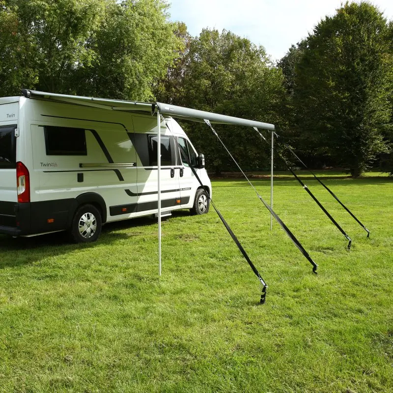 Wohnmobil mit ausgefahrener Markise, gesichert durch das your GEAR Storm Set: Vier schwarze Sturmbänder spannen die Markise ab und bieten optimalen Schutz vor Wind, ideal für Camping und Outdoor.