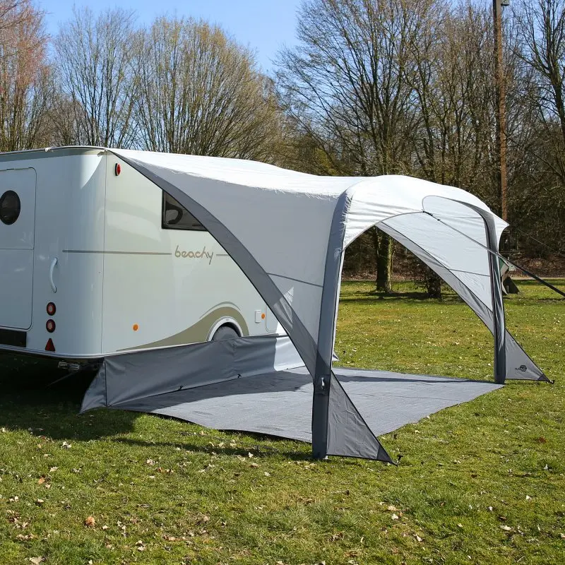 Auvent gonflable your GEAR Amalfi Air 360 gris clair, parfaitement ajusté au camping-car Hobby Beachy, avec structure arquée, tapis de sol intégré et protection latérale, installé sur une pelouse.