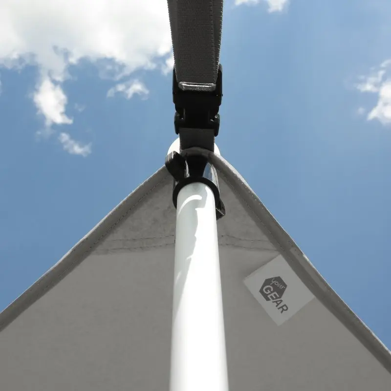 your GEAR Caravan Thermo Tarp with aluminum coating, UV80 protection, waterproof oxford polyester, shown mounted with a pole and strap under blue sky, product label visible on the tarp edge.