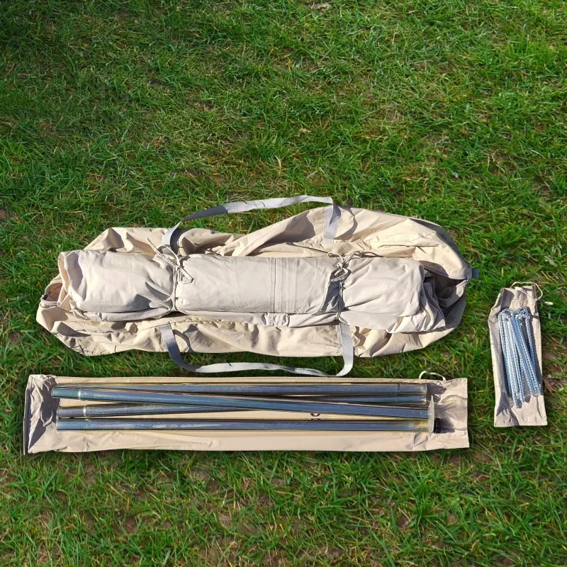 Tente étoile your GEAR Sonora 10 m : sac de transport beige, armatures métalliques, piquets et accessoires, disposés sur l’herbe. Idéal pour l’ombre, le camping et les grands événements extérieurs.