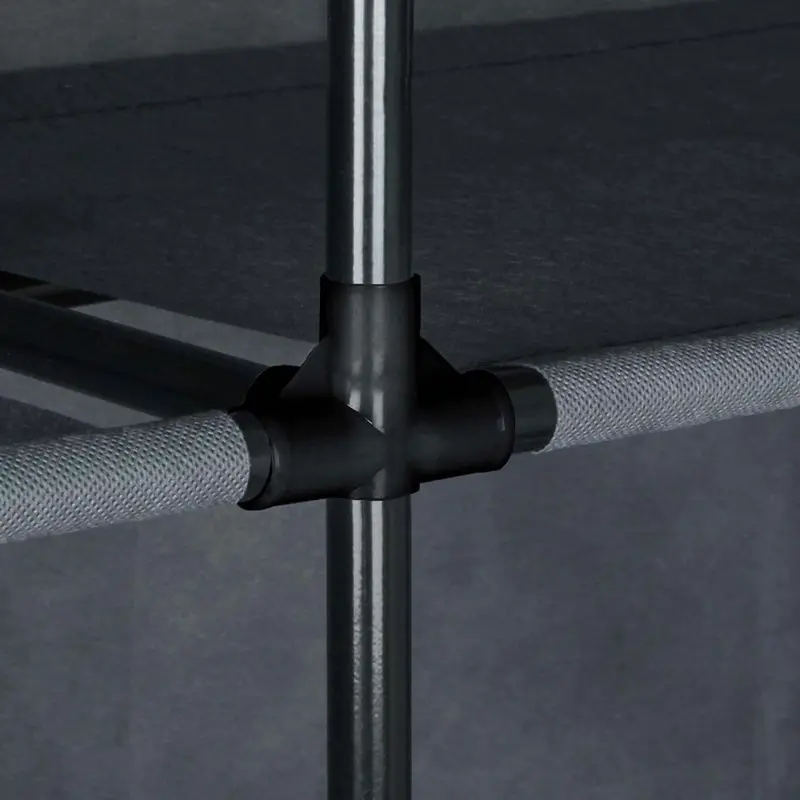 Dettaglio della struttura del yourGEAR Kleiderschrank Grado: giunzione in plastica nera che collega tubi metallici e ripiani in tessuto grigio, evidenziando la stabilità e il design modulare dell’armadio in tessuto.