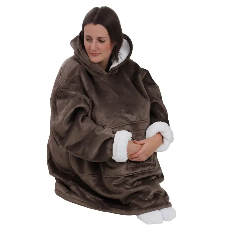Donna indossa la yourGEAR Davos Hoodie marrone, una coperta con maniche e cappuccio in formato XXXL, esterno in velour, interno in sherpa bianco, con tasca frontale e polsini soffici a contrasto.