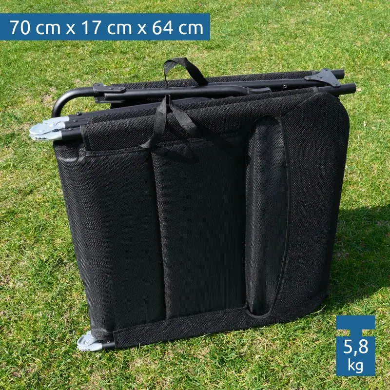 Chaise longue yourGEAR Salina 3D pliée, revêtement en mesh 3D noir, structure en aluminium, dimensions pliée 70x17x64 cm, poids 5,8 kg, adaptée au camping ou jardin, posée sur de l’herbe.