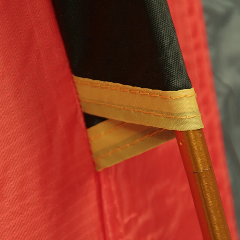Détail du 10T Zelt Silicone Valley, montrant la toile rouge et noire imperméable 5000mm, coutures renforcées et arceaux en aluminium robustes, idéal pour le trekking et le camping 3 personnes.