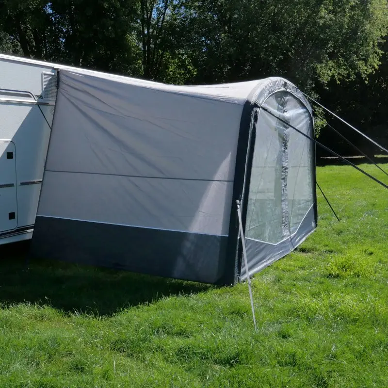 Auvent gonflable your GEAR Otranto Air 380 x 250 cm, monté sur un camping-car, avec grande paroi panoramique transparente et toit profond, installé sur une pelouse verte, idéal pour la protection solaire.