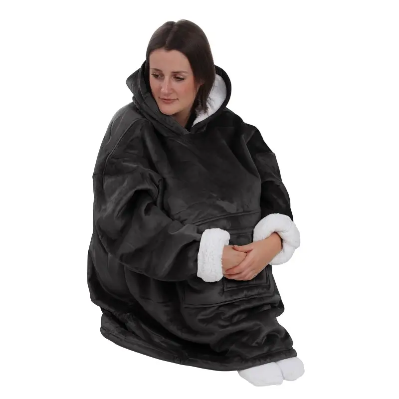 Donna indossa yourGEAR Davos Sherpa Hoodie Decke nera, formato XXXL, con cappuccio, tasche frontali, esterno in velluto liscio e interno in pile sherpa bianco, ideale come coperta indossabile unisex per il relax.