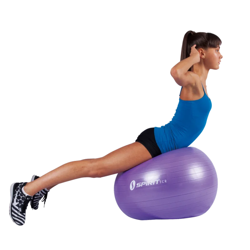 Woman exercising on a purple Spirit TCR gym ball (Ø 65 cm), demonstrating core training. The fitness ball is made of durable material and features the Spirit logo, suitable for yoga, office, and fitness use.
