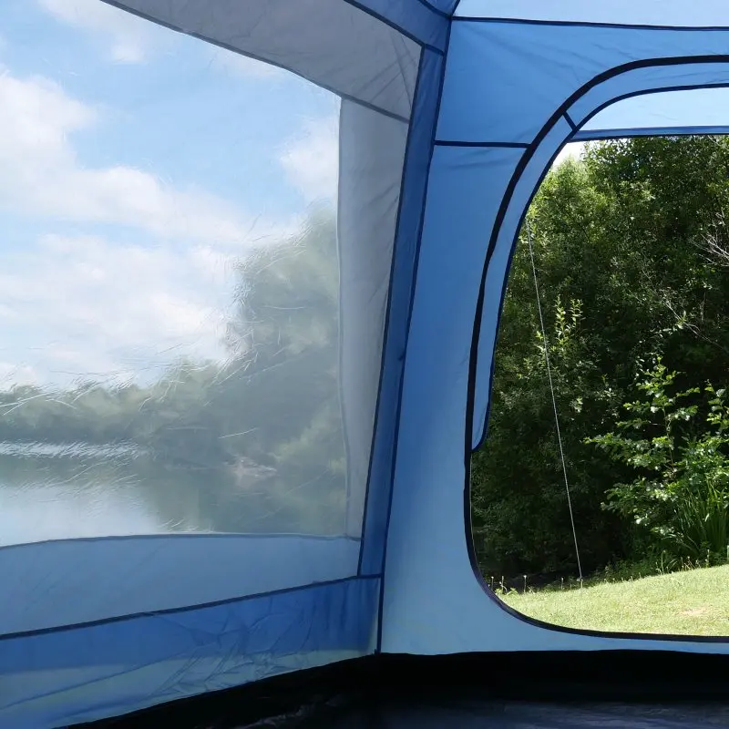 Blick aus dem your GEAR Zelt Ponza 400, zeigt großes Innenraumfenster mit Rund-Um-Insektenschutz, fest vernähtem Boden und Stehhöhe, ideal für Gruppen, Festival oder Familie im Grünen.