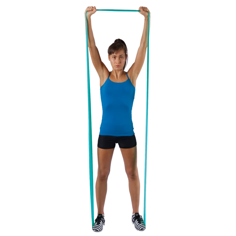 Woman demonstrating the Spirit Fitnessband, 183x10 cm, latex-free resistance band with 13.5 kg resistance, held overhead; ideal for versatile strength and rehabilitation exercises.