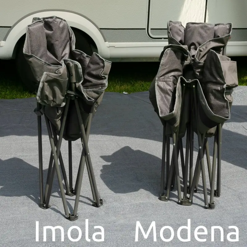 Zwei zusammengefaltete Campingstühle auf Teppich vor Wohnmobil; links der your GEAR Imola XXL Bucket Chair, extra breit, gepolstert, Two-Tone Optik, stabiler Stahlrahmen, rechts ein schmalerer Stuhl (Modena).
