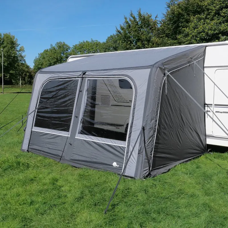 Auvent gonflable your GEAR Porto 340 Air gris, fixé à un camping-car, avec grandes fenêtres transparentes, structure robuste et toit incliné, installé sur une pelouse sous ciel bleu.