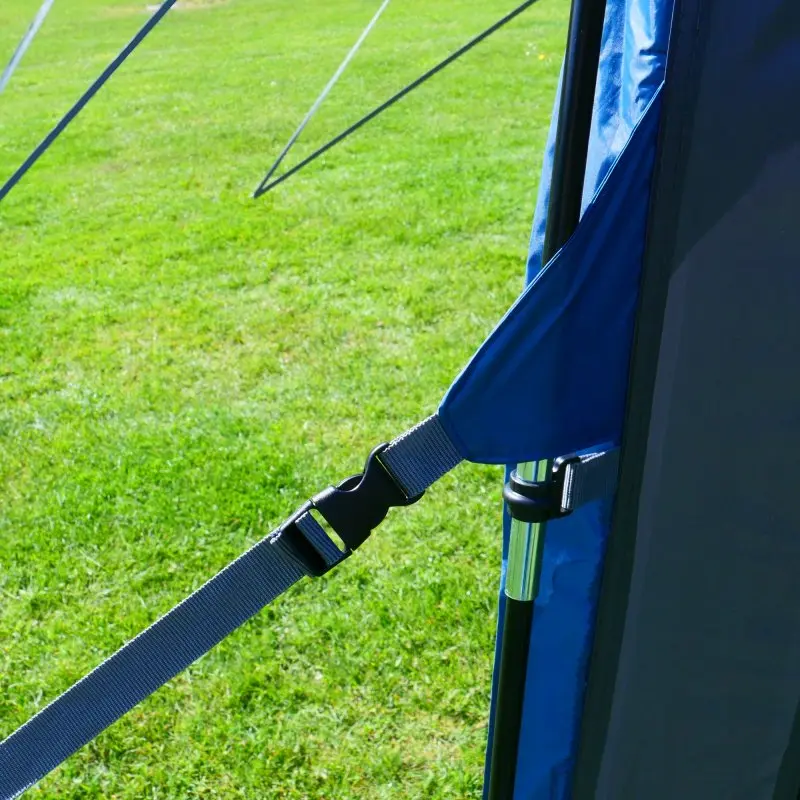 Detailaufnahme des your GEAR Panarea 320 Busvorzelts: zeigt stabile Gurtbefestigung und Gestänge, wetterfestes Material in Blau auf grüner Wiese, geeignet für Camper, UV 50+ und wasserdicht.