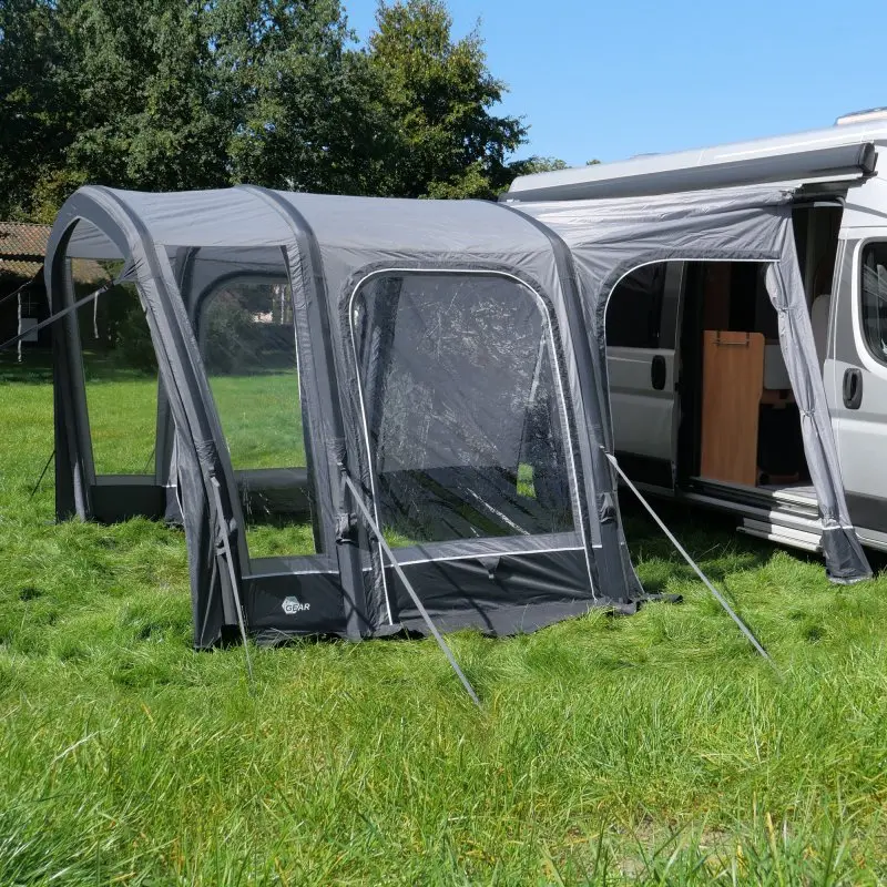 Avance de aire your GEAR Manarola para furgonetas, 320x325 cm, color gris, con ventanas grandes y estructura inflable, conectado a un camper en césped, ideal para ampliar el espacio durante el camping.
