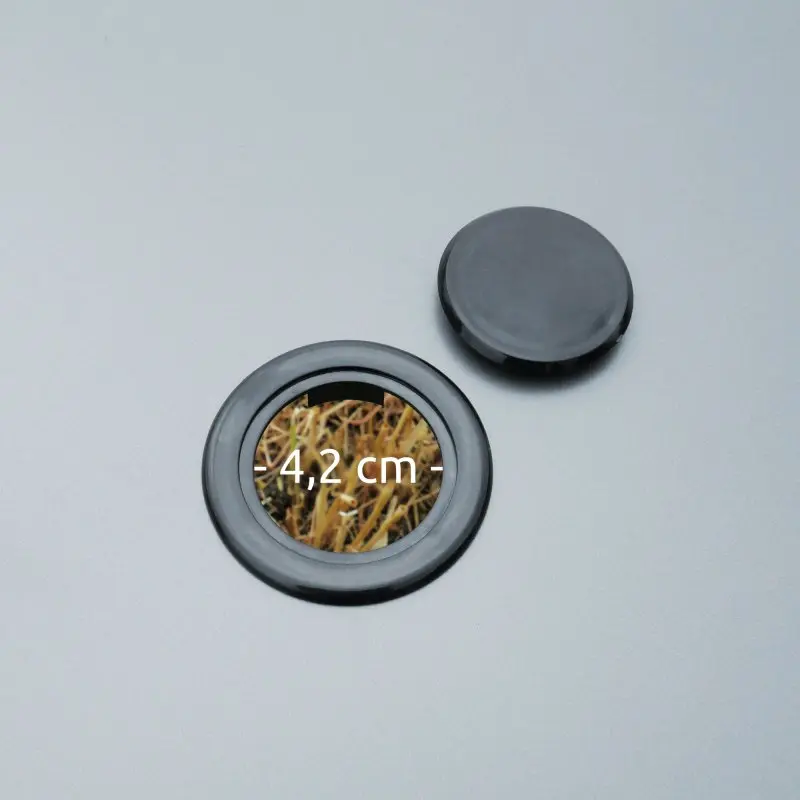 Détail du plateau du your GEAR Campingtisch Tivoli XL montrant un trou de 4,2 cm de diamètre avec couvercle, surface grise en aluminium, résistant à l’eau, idéal pour camping et jardin.