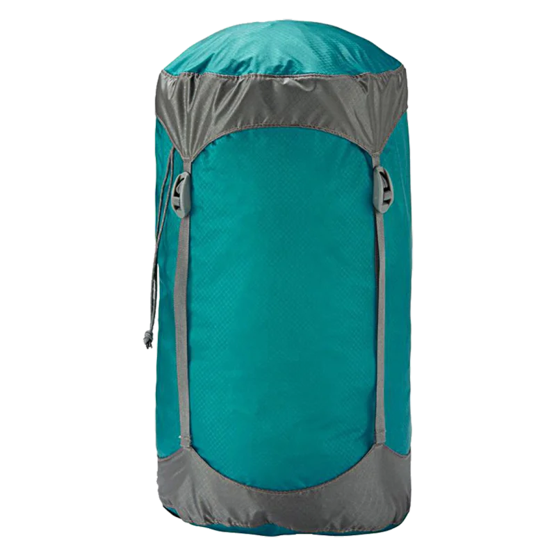 Saco de compresión Trekmates 8L en nailon azul con detalles grises, cuatro correas de compresión, cierre de cordón y tapa superior. Ideal para dormir, resistente al agua y ultraligero.