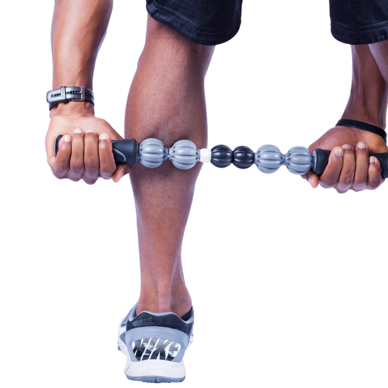 Homme utilisant le rouleau de massage musculaire Spirit sur son mollet, bâton à poignées noires et rouleaux gris et noirs, conçu pour l’auto-massage et la récupération musculaire après l’entraînement.