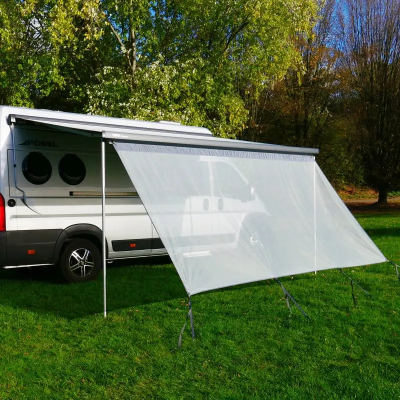 Winddurchlässige your GEAR Capri Sun Blocker Markisen-Vorderwand (4,8 x 2 m) am Campingbus montiert; lichtdurchlässiges Spezialgewebe bietet Sonnen- und Sichtschutz, gespannt mit Abspannleinen auf Wiese.